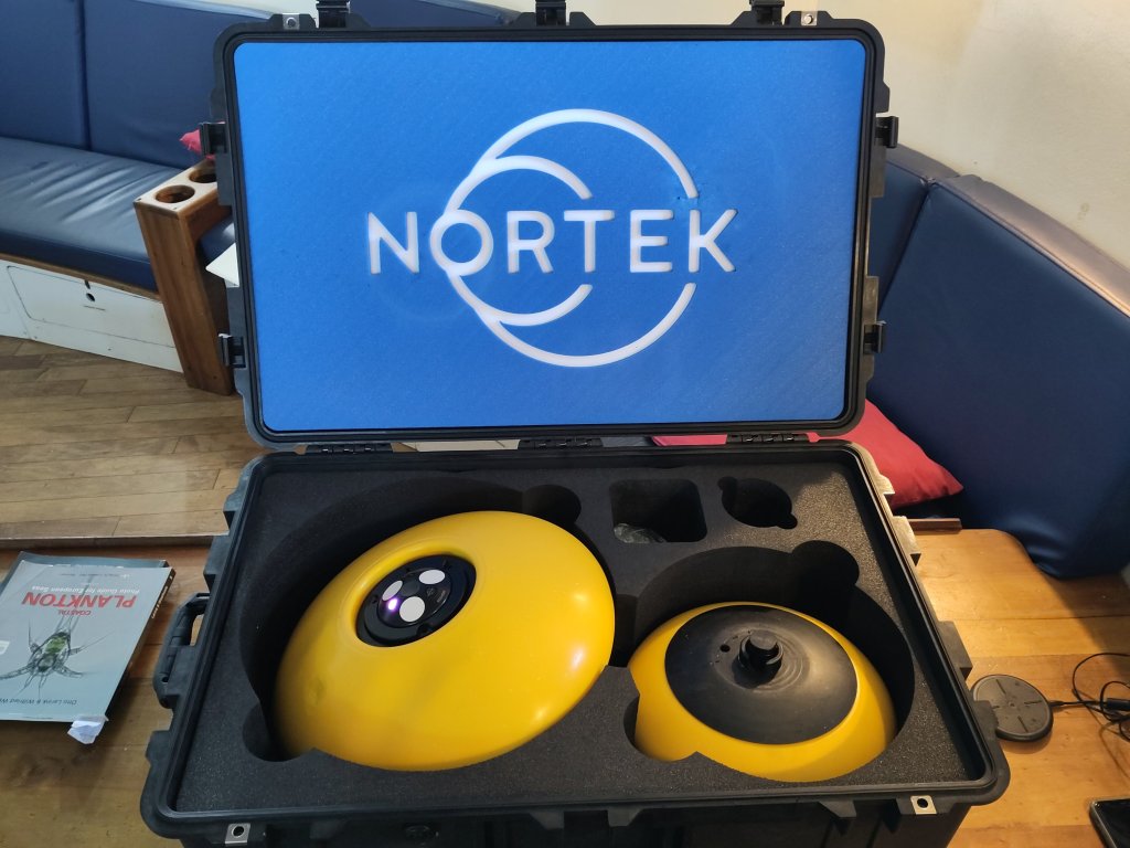 ECO acoustic doppler current profiler set within its deployment buoys (left) and associated release mechanism (right) within the transport case. The inductive charger can be seen on the bench to the right of the case.